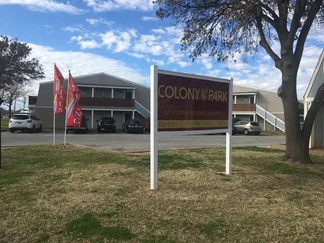 a sign in the grass in front of a building