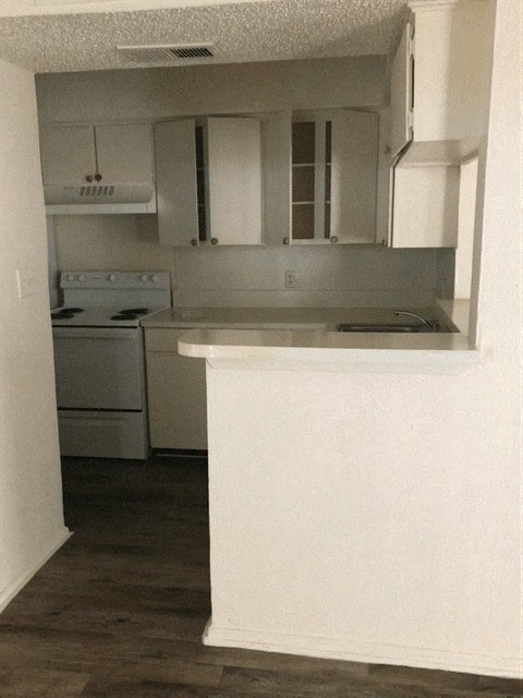 an empty kitchen with white cabinets and white appliances