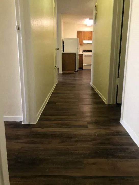 a hallway with a wooden floor and white walls
