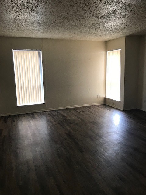 an empty living room with two windows
