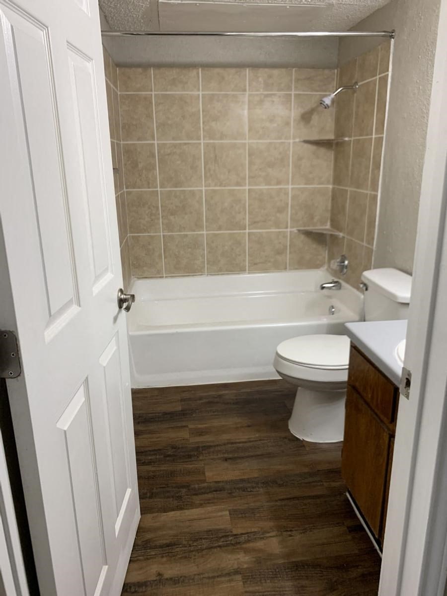 a white toilet sitting next to a white bath tub