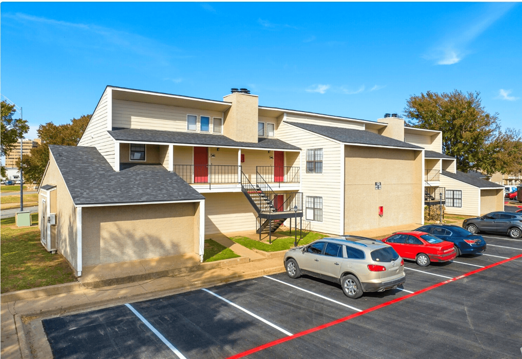 A parking lot with cars and a building in the background.