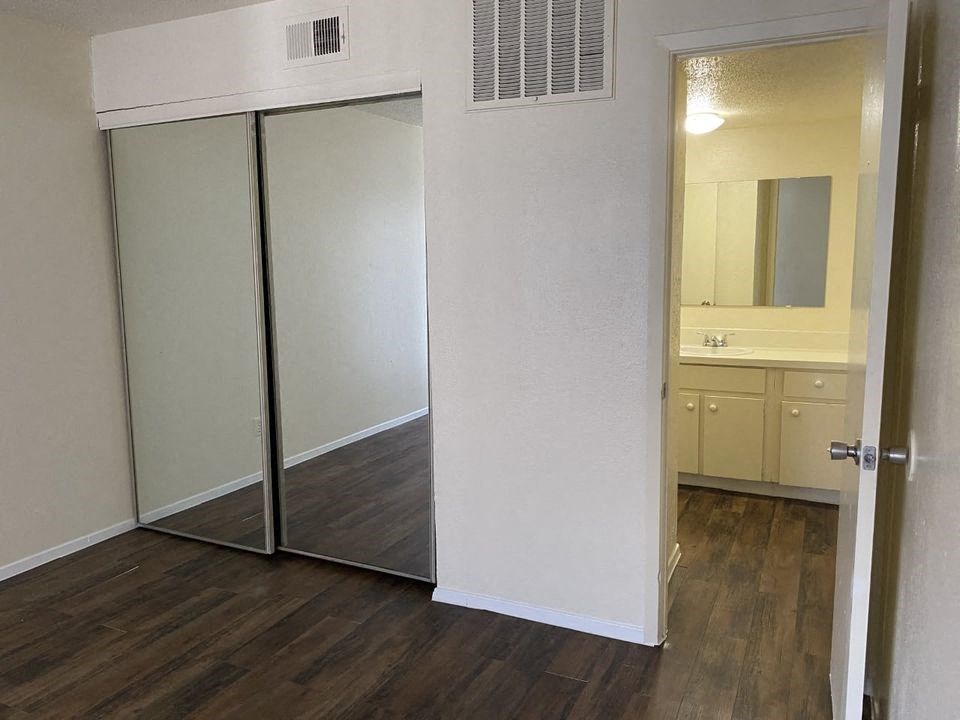 an empty bedroom with a mirror and a sink