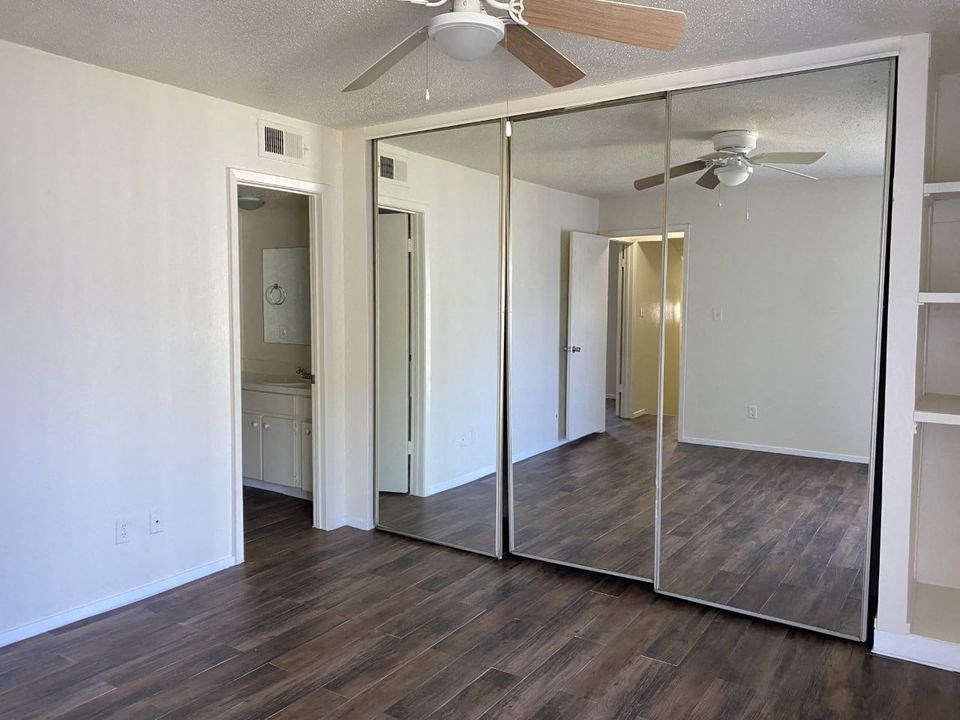 an empty living room with a ceiling fan