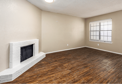 A room with a fireplace and wooden floors.