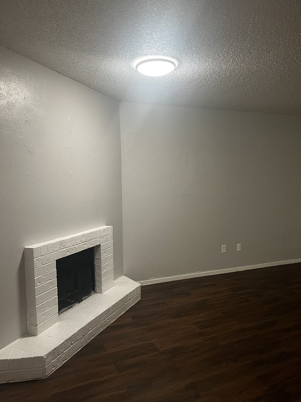 a living room with a fireplace and hardwood floors
