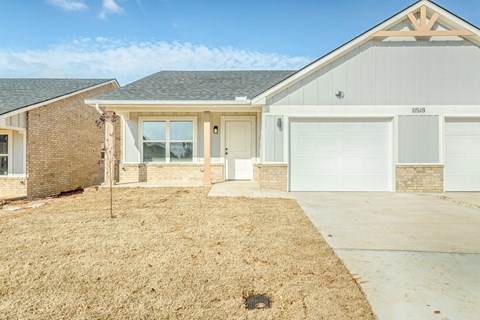 A house with a garage and a driveway in front.