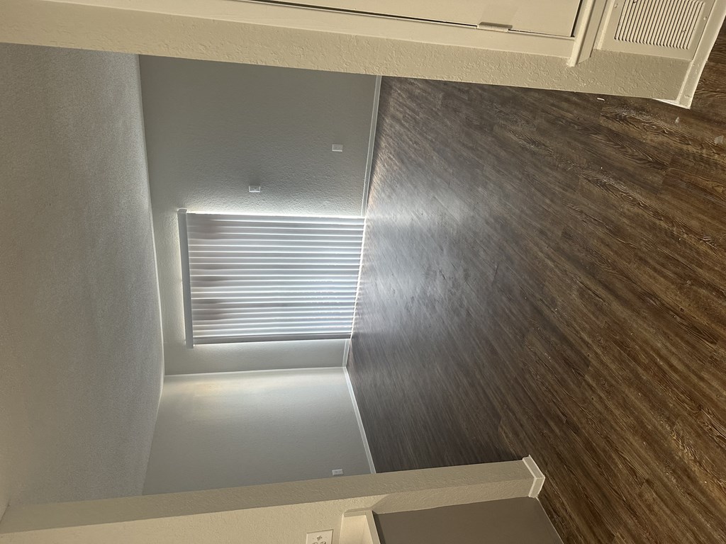 a view from the top of the stairs looking down into the living room