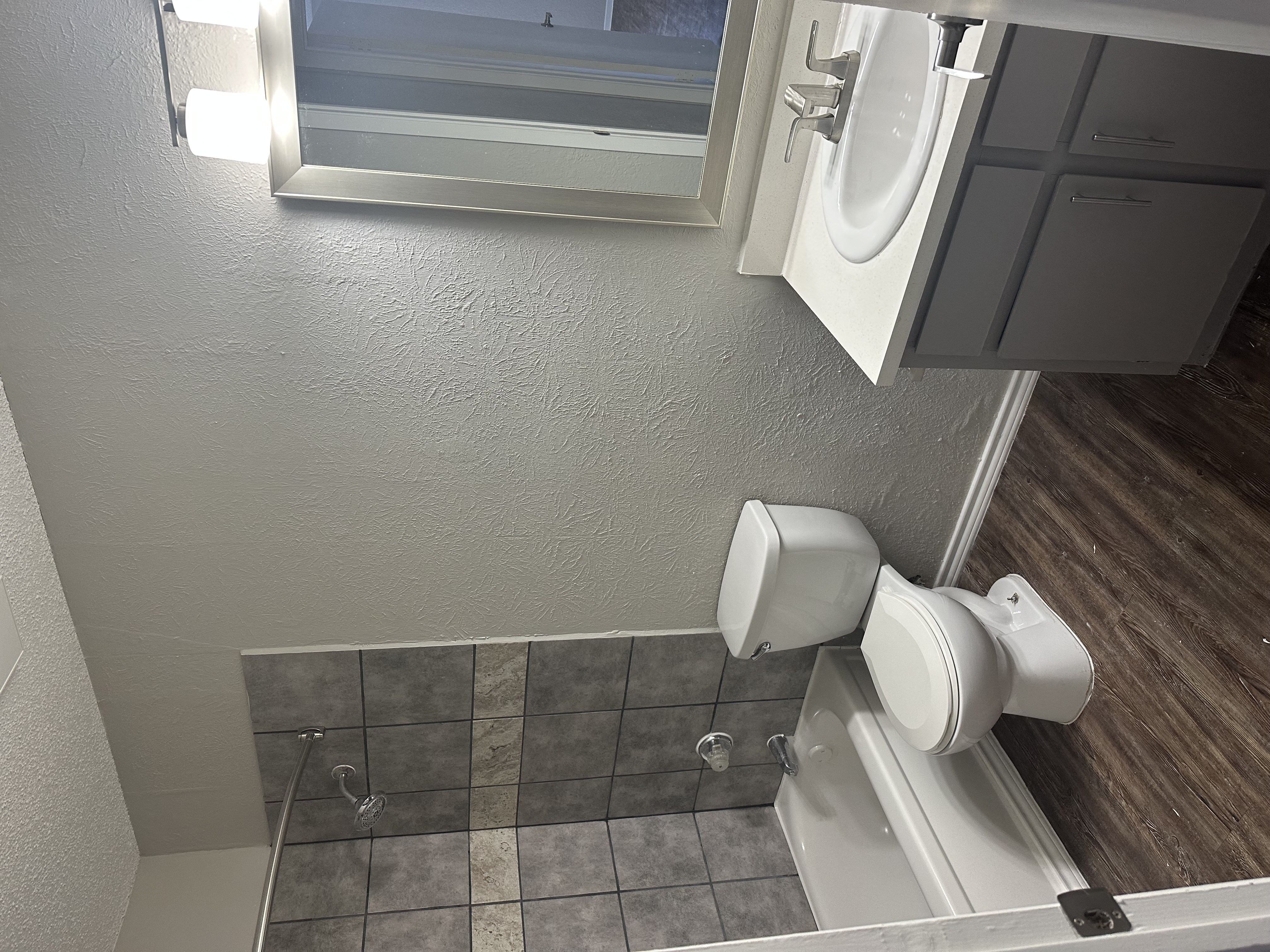 a small bathroom with two toilets and a window