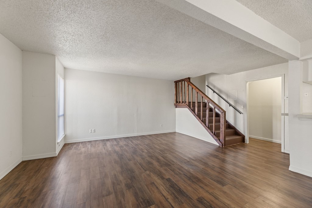 A room with wooden floors and a staircase.