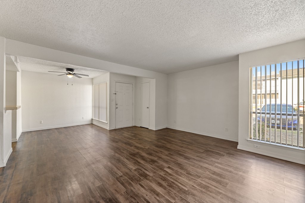 A room with wooden flooring and a ceiling fan.
