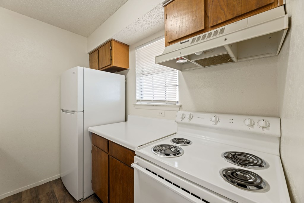 A white stove and refrigerator in a kitchen.
