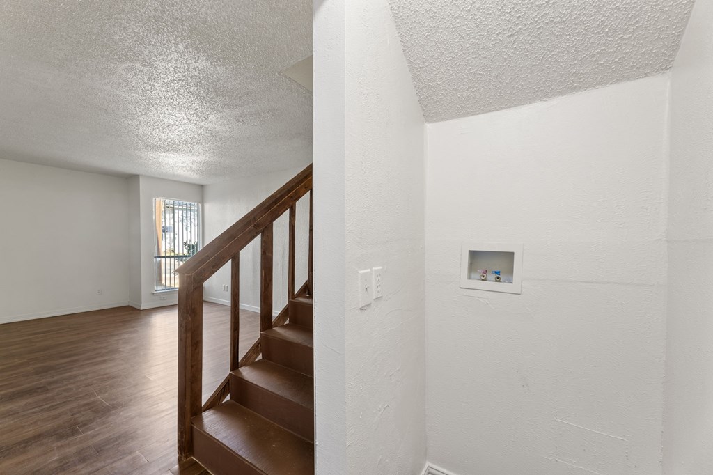 A staircase with a white wall and a small picture frame on the wall.