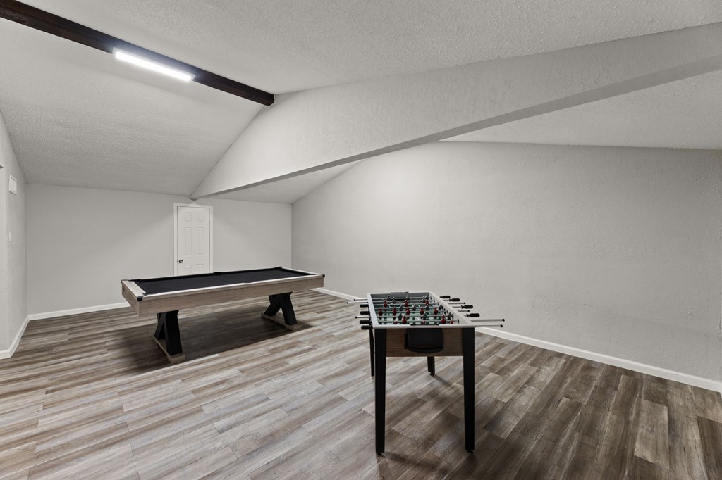 A room with a table and a foosball table.