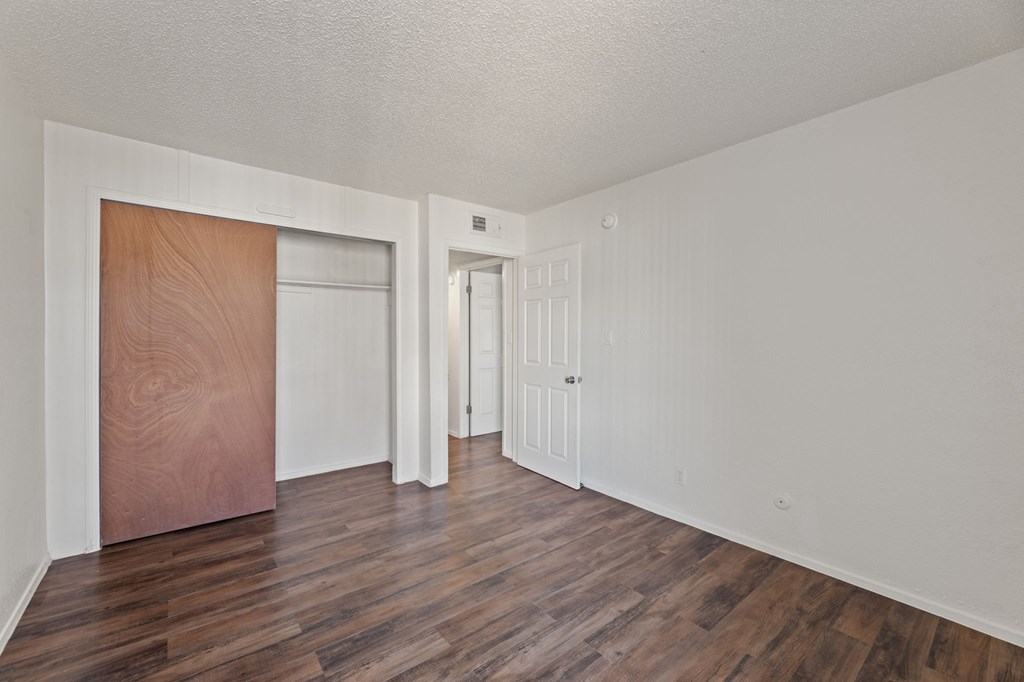 A room with a white wall and a brown door.