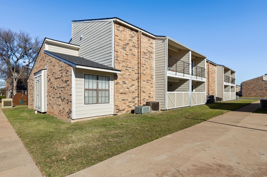 A building with a brown brick facade and a white door.