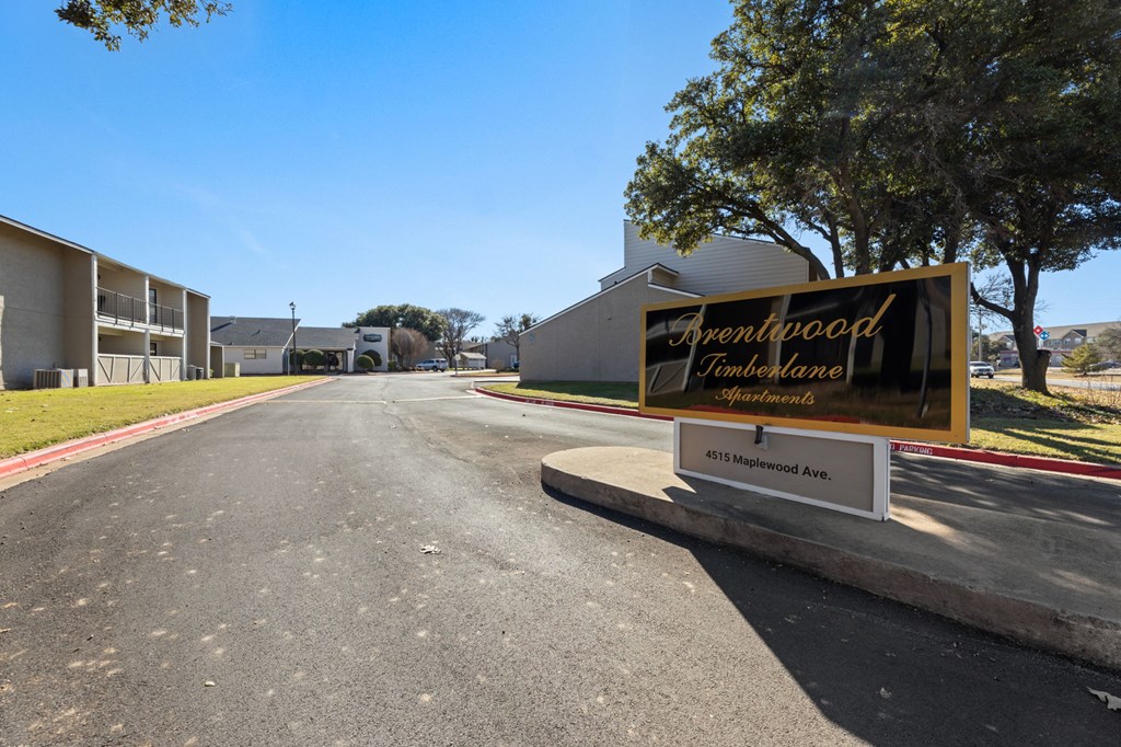 A sign for Arentwood Apartments is on the side of a street.