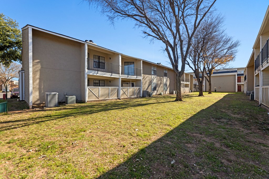 Apartment complex with a grassy area in front.
