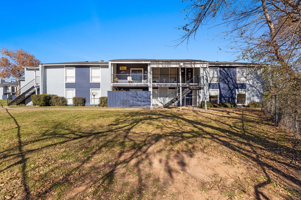 A large, modern building with a flat roof and a balcony on the second floor.