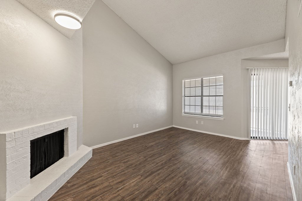 A room with a fireplace and wooden flooring.