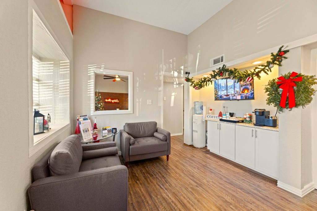 A living room with a grey couch and a Christmas tree.