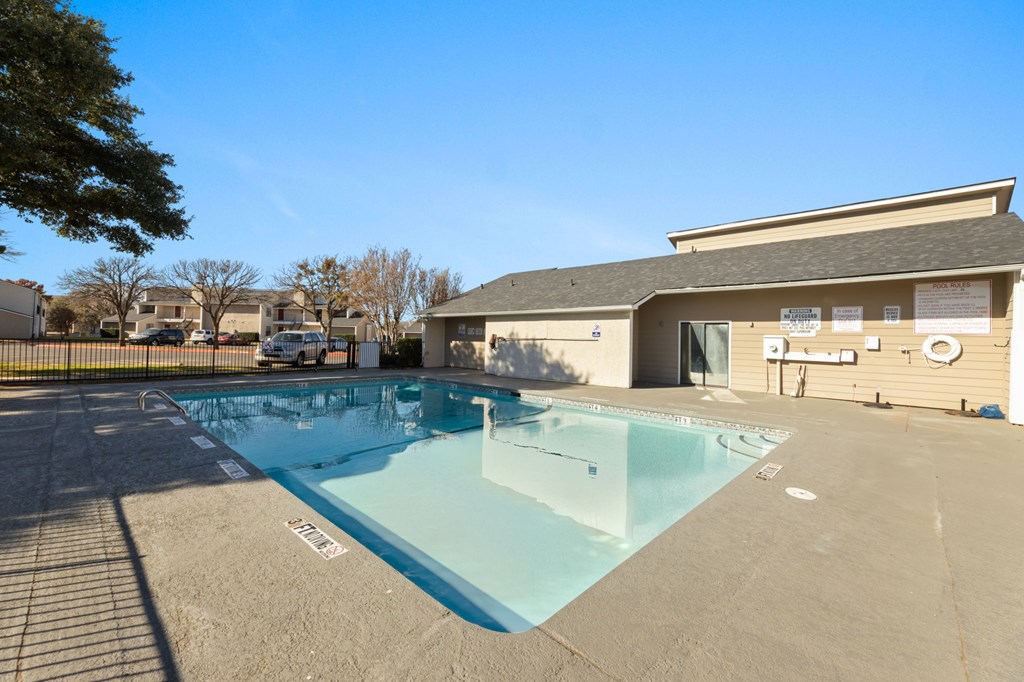 A small pool in front of a building with a sign on it.