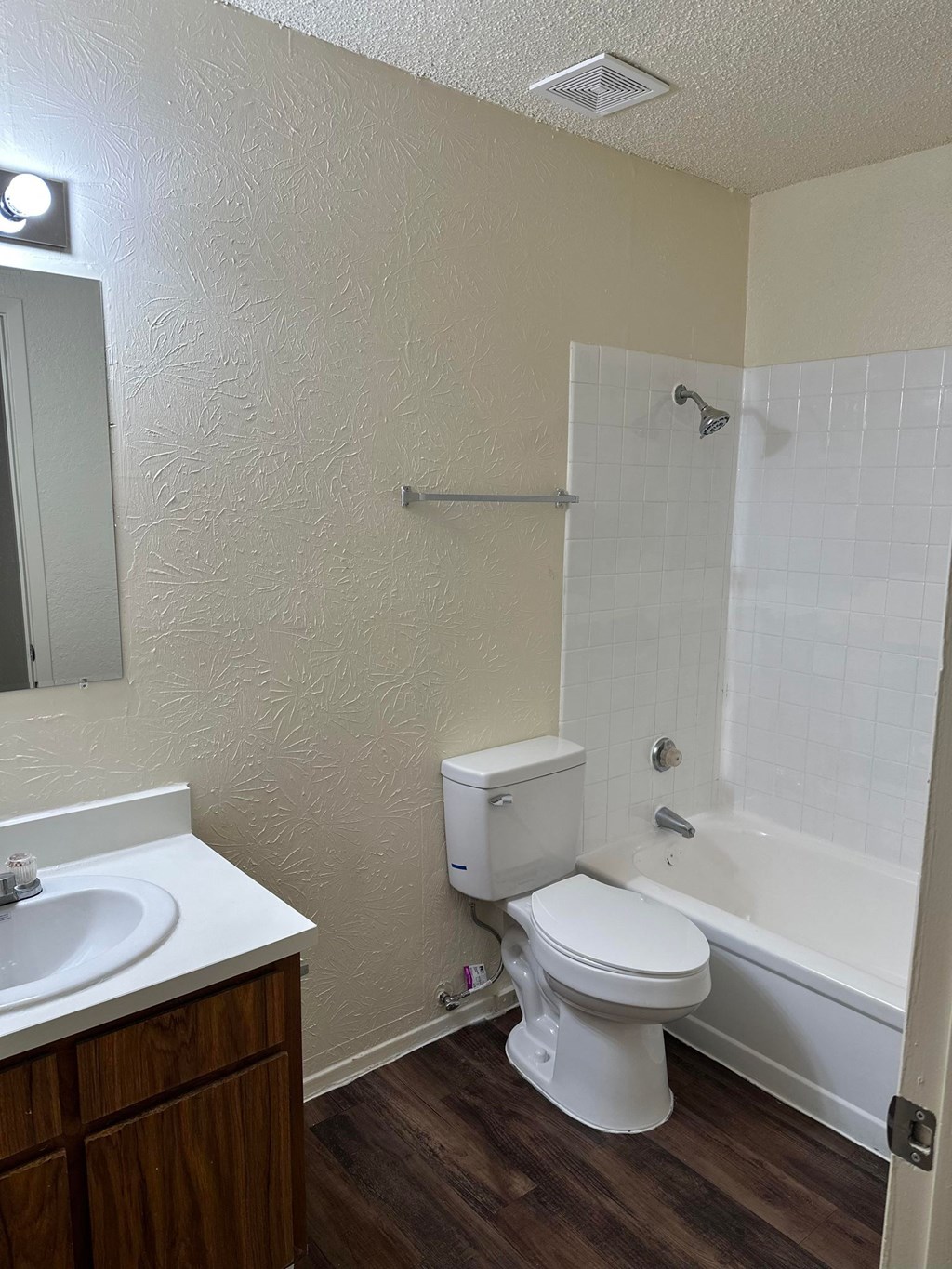 A white toilet sits next to a white sink in a small bathroom.
