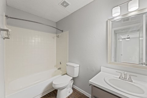 A white toilet sits next to a white sink in a bathroom.