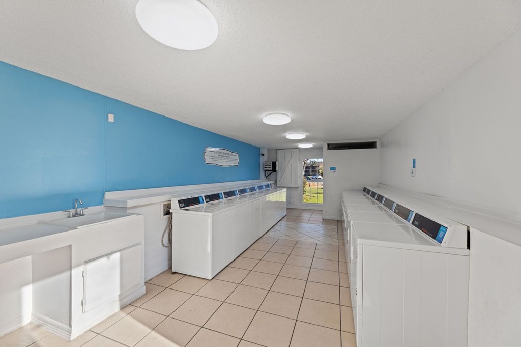 A laundromat with rows of washers and dryers.