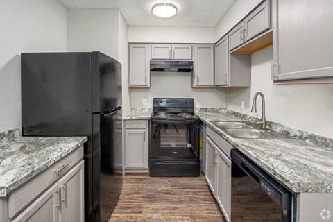 a kitchen with granite counter tops and black appliances