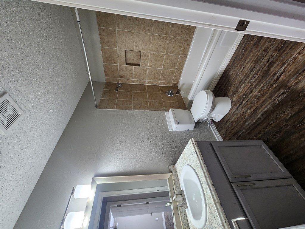 A bathroom with a tiled shower and a toilet.