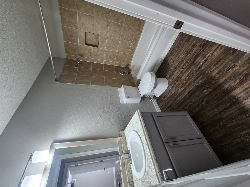 A bathroom with a toilet, sink, and shower.