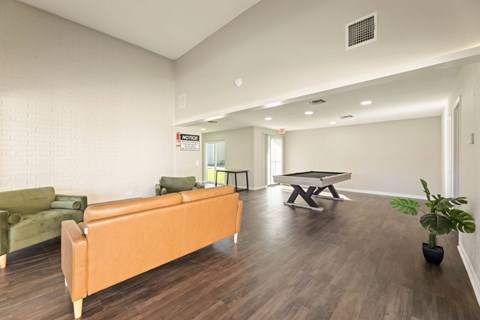 A living room with a sofa, a coffee table, and a plant.