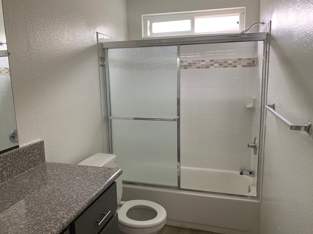 a bathroom with a shower and a sink and a toilet