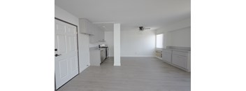 A spacious kitchen with white cabinets and a ceiling fan.