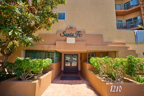 The Santa Fe building has a brown sign and a black door.