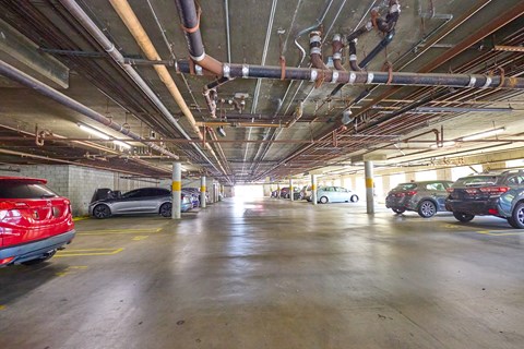A parking garage with cars parked on the ground floor.