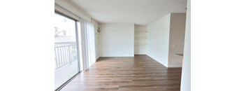 A room with wooden flooring and white walls.