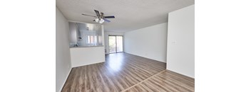 A room with a ceiling fan and wooden flooring.