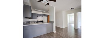 A kitchen with a white counter top and a ceiling fan.