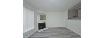 A modern living room with a fireplace and grey flooring.