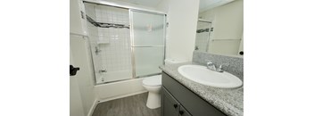 A white toilet sits in a bathroom next to a sink.
