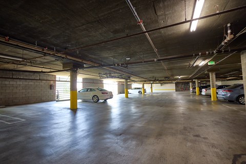 A parking garage with a white car parked in the middle.