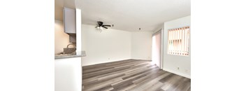 A room with a ceiling fan and wooden flooring.