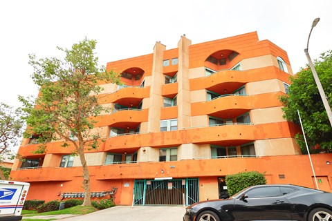 A black car is parked in front of a building.