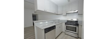 A kitchen with white cabinets and a granite counter top.
