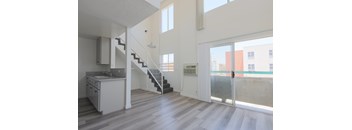 A modern kitchen with a staircase leading to the upper floor.