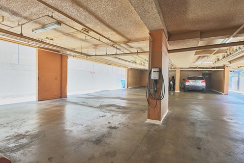 A car is parked in a garage with a charging station.