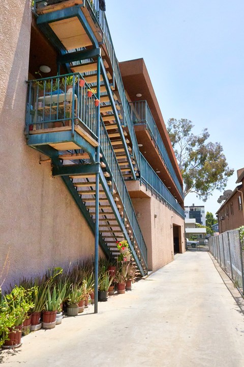 A staircase with a metal railing and steps leading up to a balcony.
