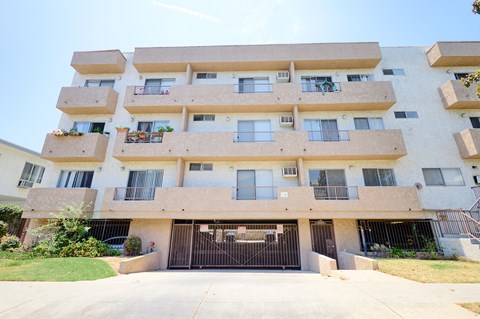 A large apartment building with a black gate in front.